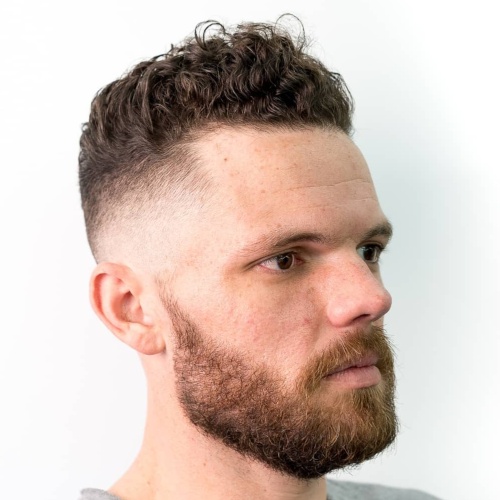 high top curly hair low fade side part hairstyle beard