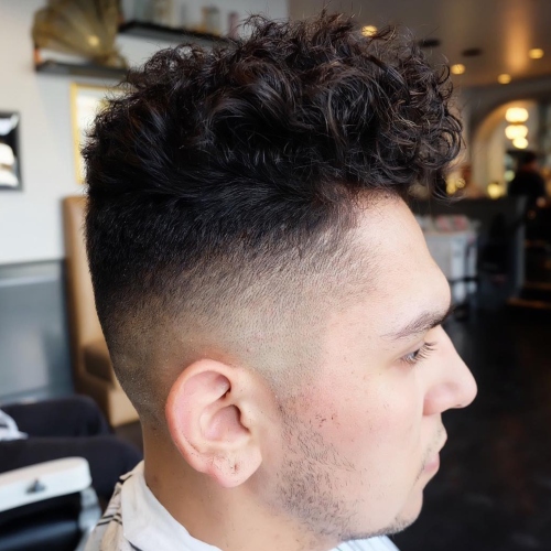 top curly side part taper fade wavy hairstyle